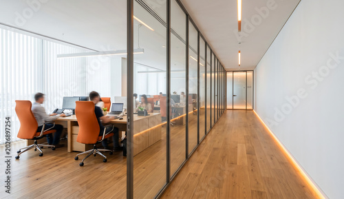 Modern Tech-Style Office with Glass Partitions and Warmly Lit Corridor
