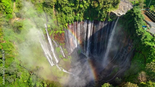 Aerial view of Tumpak Sewu Waterfall with multiple cascades falling into a misty canyon surrounded by lush tropical forest Kecamatan Pronojiwo, Jawa Timur, Indonesia.