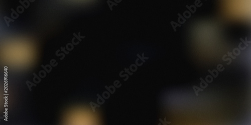 Abstract grainy gradient background with dark black canvas and warm gold bokeh lights