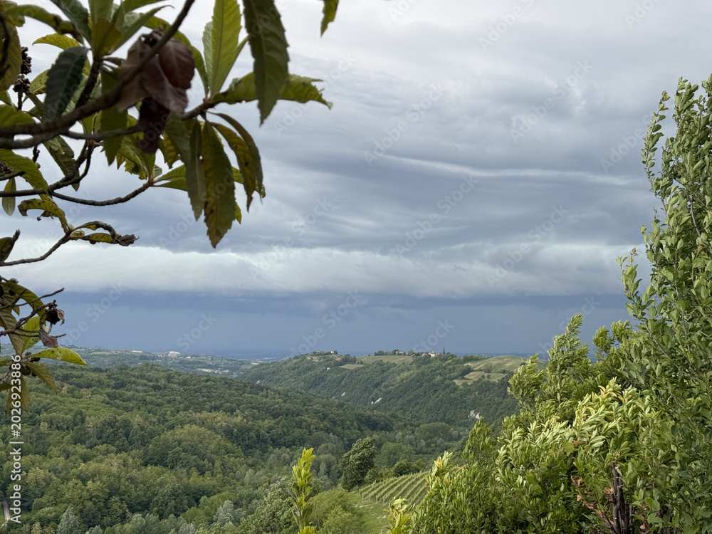 Fototapeta premium Stormy Clouds Over Rolling Green Hills in Piedmont Italy Landscape
