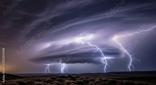 Dramatic lightning storm with multiple bolts illuminates dark cloudy sky over vast landscape