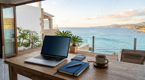 Laptop calculator blue notebook pen and coffee on wooden desk overlooking sea