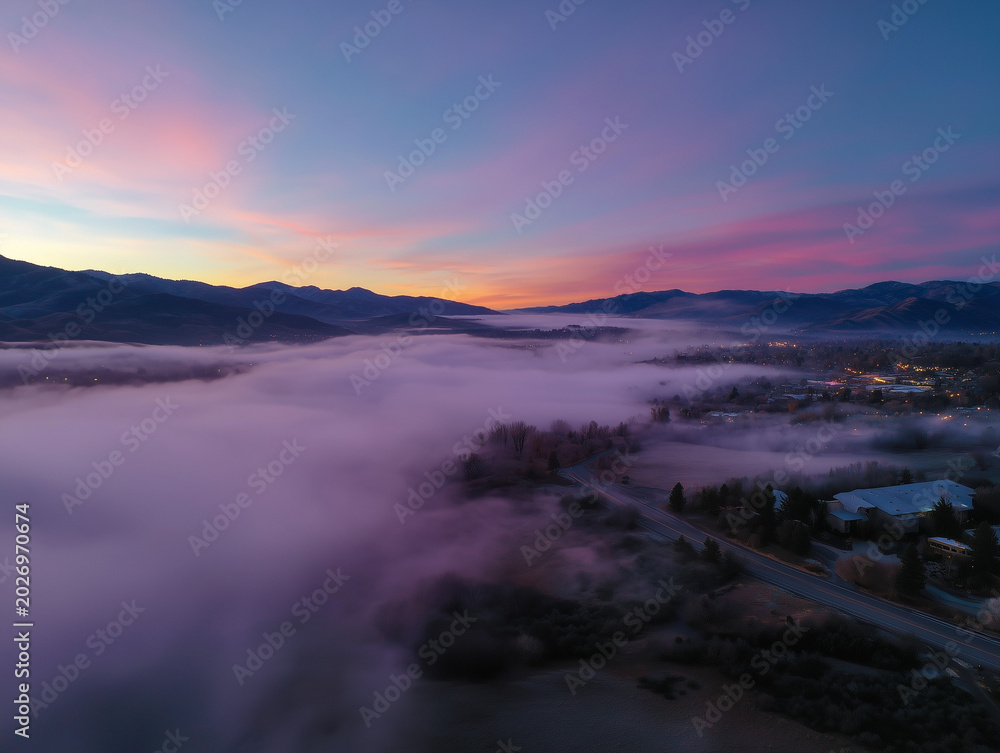 Fototapeta premium Aerial view valley fog covering a beautiful landscape during dawn
