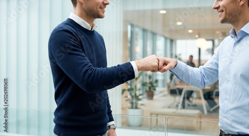 Professionals sealing agreement with a fist bump in office