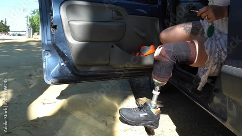 Independent woman with a prosthetic leg getting out of a car. Brave female amputee overcoming challenges and living an active, normal life