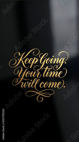 Elegant gold foil calligraphy lettering of the motivational quote Keep Going Your time will come on a sleek black background.