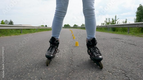An adult woman sets up yellow roller skating training chips.