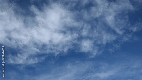 White and gray clouds move in two directions in this timelapse filling the bluse sky. The sky fills the frame.
