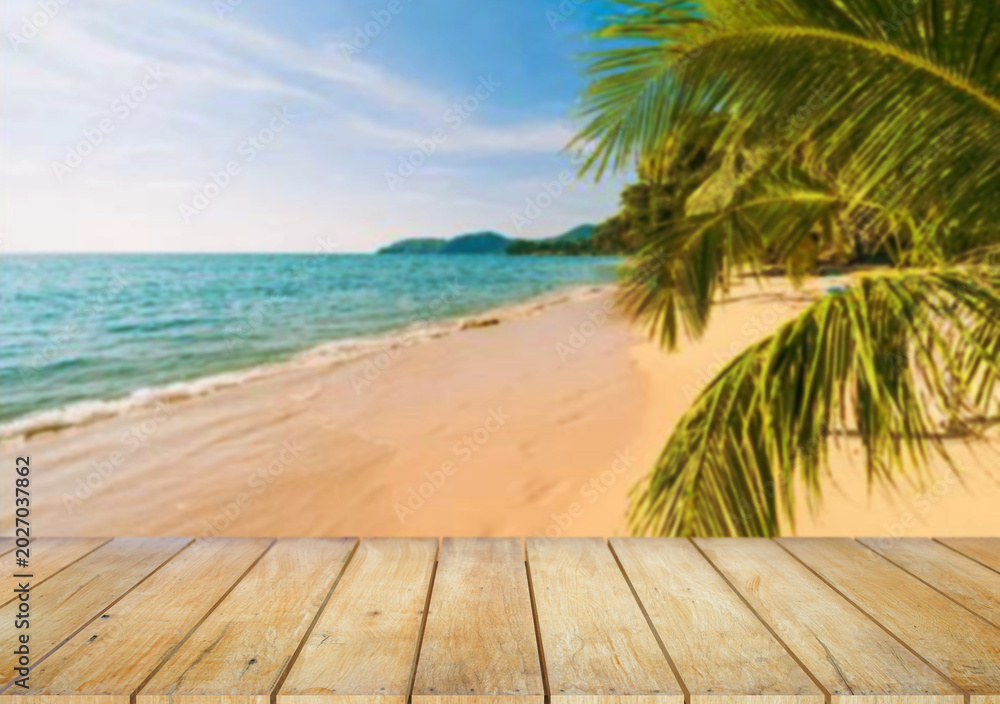 Fototapeta premium Wooden table top on the beach or sea.Party on the beach sunshine time concept.For montage product display or design key visual layout.View of copy space.
