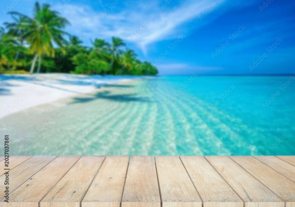 Fototapeta premium Wooden table top on the beach or sea.Party on the beach sunshine time concept.For montage product display or design key visual layout.View of copy space.