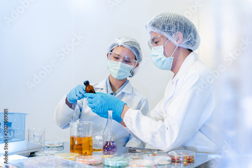 Bild auf Leinwand Two researchers inspect a small bottle in a laboratory