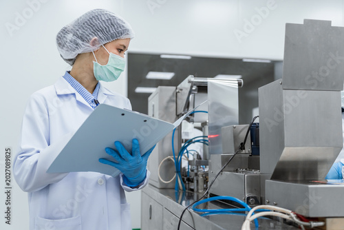 Foto Clean food factory worker inspects production line with cli