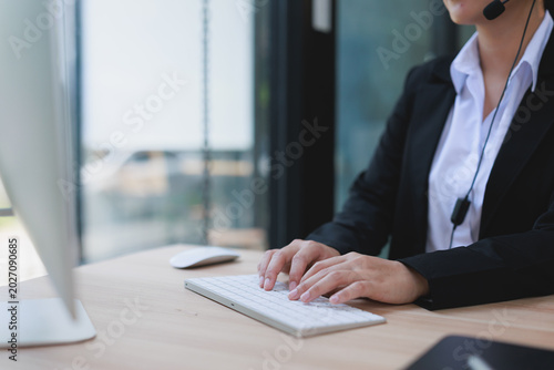 Tableau sur toile Customer support representative typing on a keyboard, wearing a headset, assisti