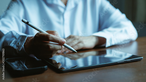Schilderij op canvas Business professional using stylus on tablet for paperless digital operations and workflow management in modern corporate technology