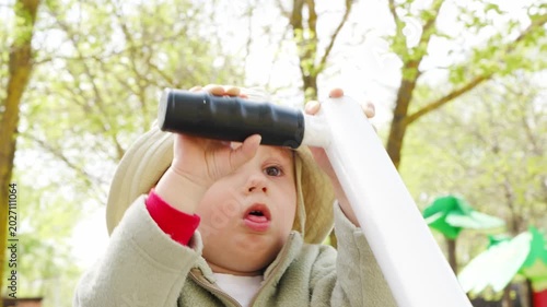 Child plays with exercise machines outdoors in park