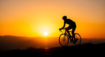 Cyclist riding into sunset on mountain road