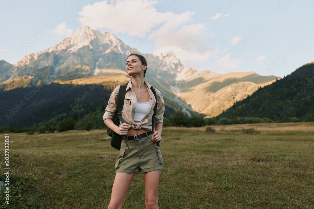 Fototapeta premium Woman hiker enjoying outdoor adventure in a mountainous landscape, wearing casual outfit with backpack, smiling as she explores expansive scenic valley