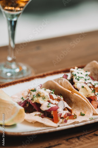 Gourmet Tacos with Cream Sauce and Lime on Rustic Table