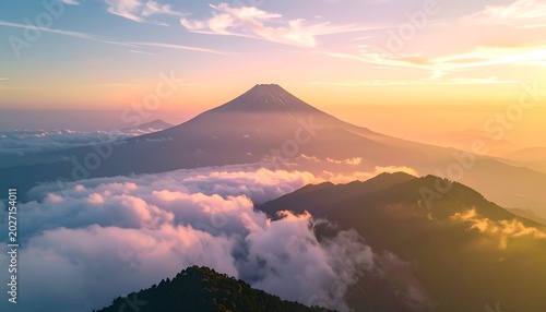 Majestic mountain peak rises above clouds at sunrise; serene, scenic vista