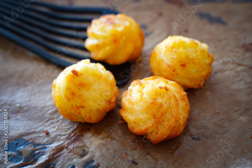 Bild auf Leinwand Crispy golden potato croquettes arranged on baking paper in a kitchen atmosphere
