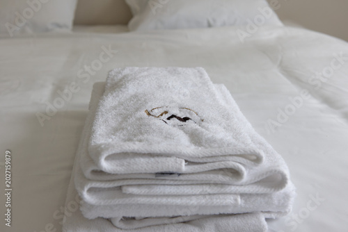 Serviettes blanches pliées sur lit d’hôtel – ambiance propre et minimaliste