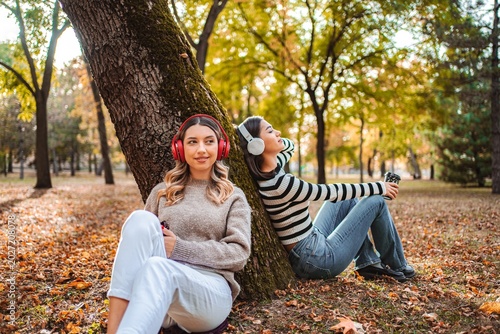 Enjoying autumn vibes together, two girls share peaceful moments in the park