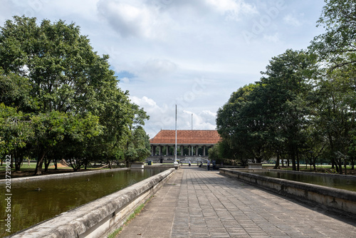 12.09.2025 Colombo, Sri Lanka. Long stone walkway leading to Independence Memorial Hall pavilion with ponds and trees in Colombo, Sri Lanka.