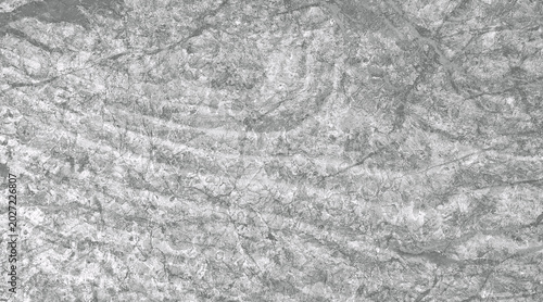 Photos A close-up abstract texture of a weathered rock surface with subtle, swirling patterns in shades of grey and white
