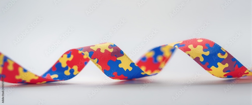 Obraz premium Bright satin puzzle ribbon showcasing autism awareness cause