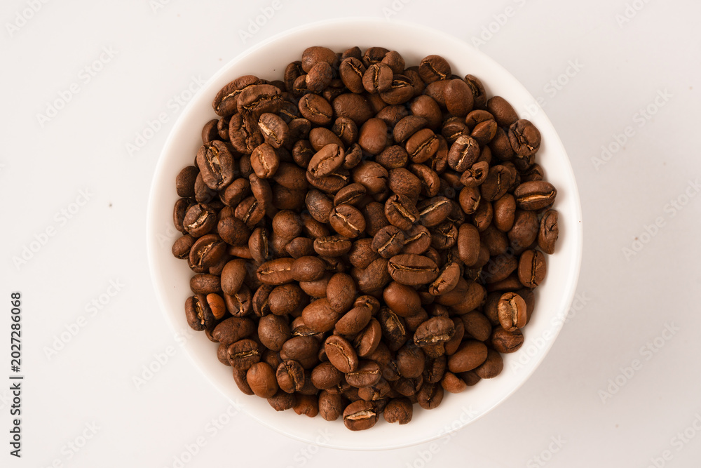 Fototapeta premium Coffee beans on a white background. Top view. Coffee beans texture.