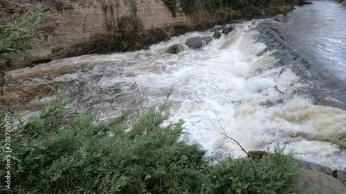 The Weiss river running between half timbered houses, Kaysersberg, Alsace, France, Europe. River with strong current flowing through the rocks.