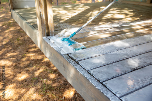 Cleaning wooden terrace floor with wet mop outdoors, soap foam detail. Concept: house cleaning