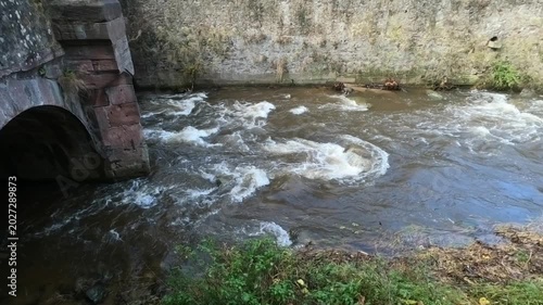 The Weiss river running between half timbered houses, Kaysersberg, Alsace, France, Europe. River with strong current flowing through the rocks.
