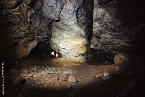 Fotografi Subterranean chamber with small daylight opening, illuminated floor and distant