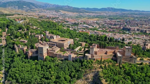 High angle view of the historic Alhambra palace complex and Alcazaba fortress in Granada. Famous UNESCO medieval Moorish architecture surrounded by scenic Andalusian mountains in Spain.