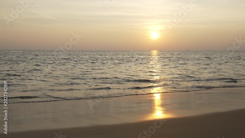 Serene Sunset Over Calm Ocean with Gentle Waves Lapping at Sandy Beach Creating Peaceful and Tranquil Atmosphere