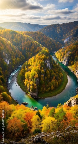 A majestic river bend cuts through autumn-hued mountains, bathed in warm sunlight