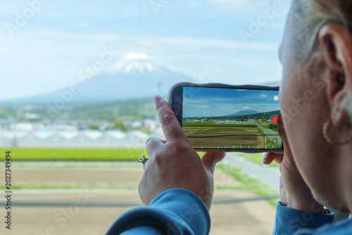 Foto Woman uses a phone to take photos of Mt