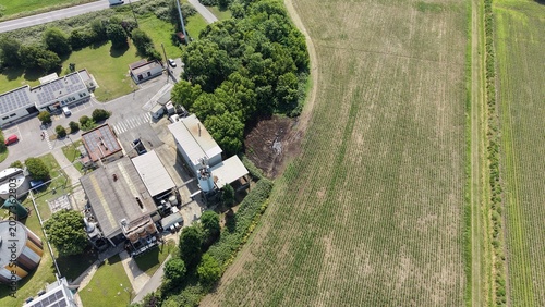 Aerial View of Industrial Site and Agricultural Field: An overhead drone shot captures an industrial complex adjacent to a vast agricultural field, showcasing the intersection of industry and farming.