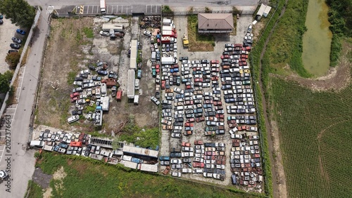 Фотография Salvage Yard Aerial View: An expansive aerial perspective captures a sprawling salvage yard filled with rows of vehicles awaiting repurposing or recycling