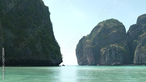 Serene View of Towering Limestone Cliffs and Tranquil Turquoise Bay Under Clear Blue Sky Tranquil Escape to Natures Beauty