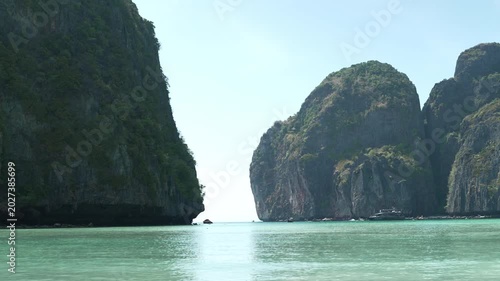 Serene View of Towering Limestone Cliffs Surrounding Tranquil Turquoise Bay Under Clear Blue Sky