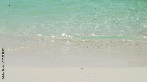 Serene Beach Scene with Gentle Waves Lapping Sandy Shore, Showcasing Clear Turquoise Water and Soft White Sand, Creating Tranquil and Inviting