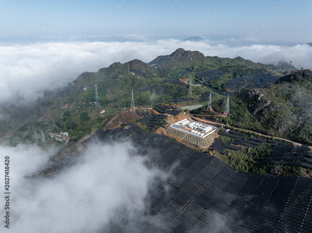 Obraz premium aerial view of solar power plant on mountain top surrounded by sea of clouds
