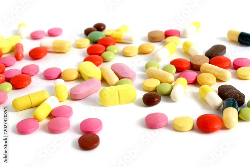 There is a pile of brightly colored pills on a white background.
