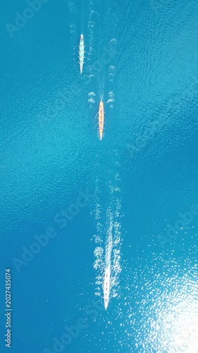 Top Down Aerial View of Rowing Boats Competing in a Race on Turquoise Sea. High quality 4k footage