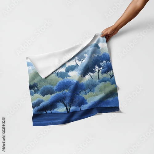 Person Holding a Fabric With a Blue Tree Design in a Bright Space