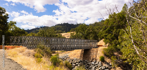 Temporary steel truss modular bridge installed over a rural creek washout