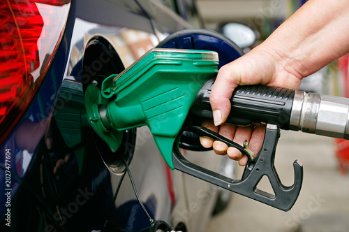 Woman filling a car with petrol, United Kingdom