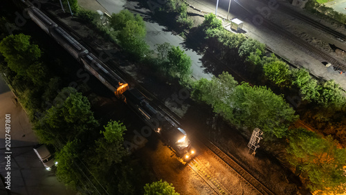 Cuadro en lienzo Aerial view of freight train moving on tracks night city